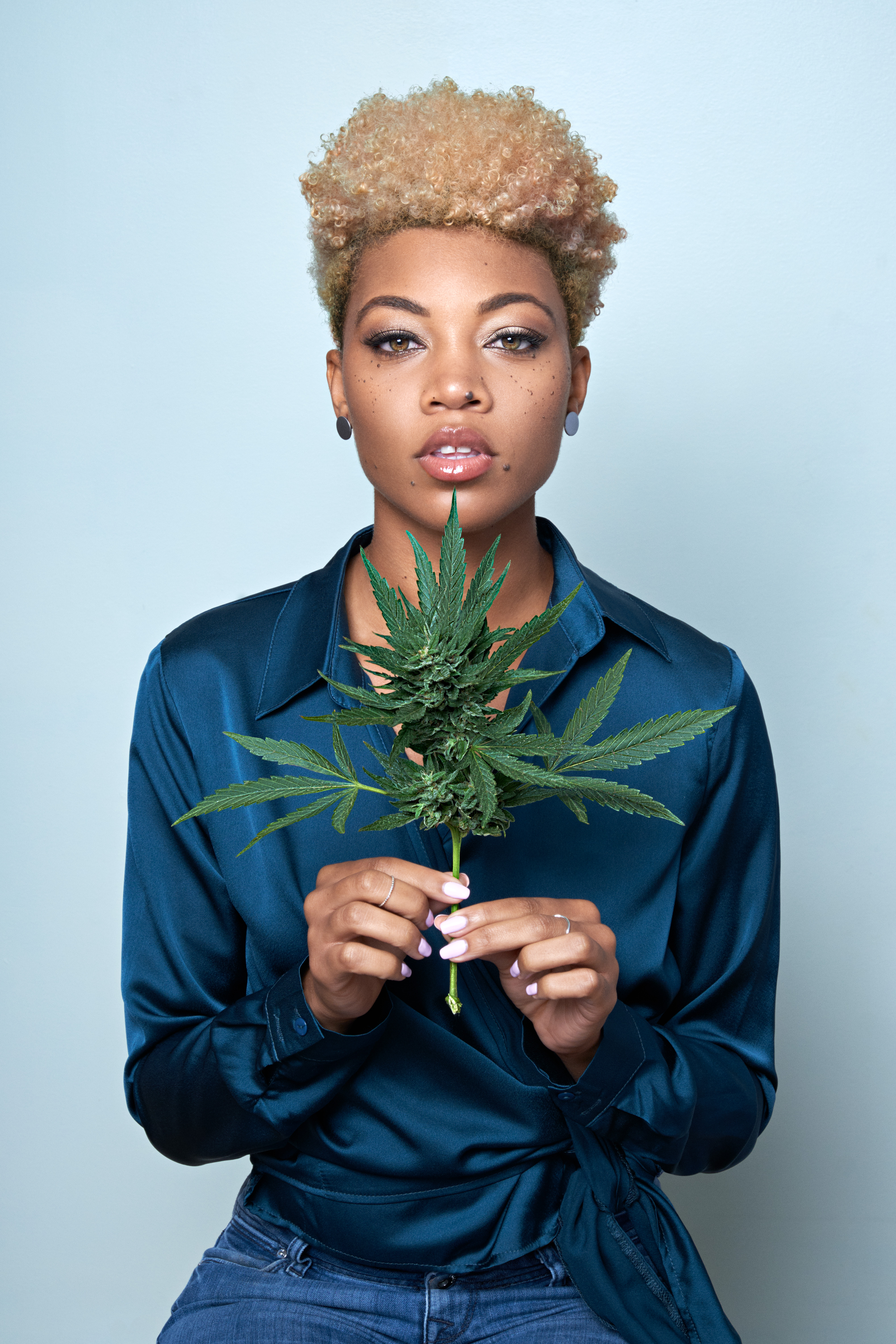 woman holding cannabis leaf
