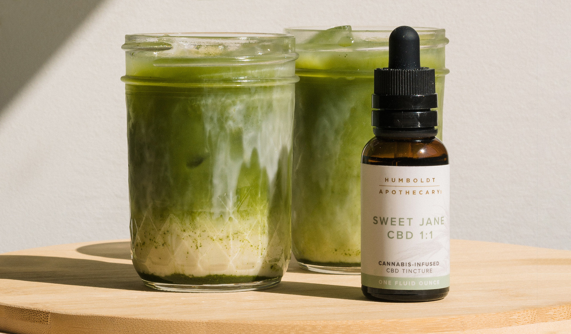 sweet jane tincture in front of match lattes on table